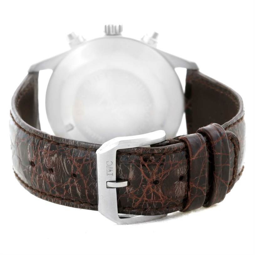 The image shows the back view of an IWC Pilot IW325110 Men's Stainless Steel Silver Dial IW325110 Men's Stainless Steel Silver Dial watch, highlighting its brown leather strap and metal buckle.