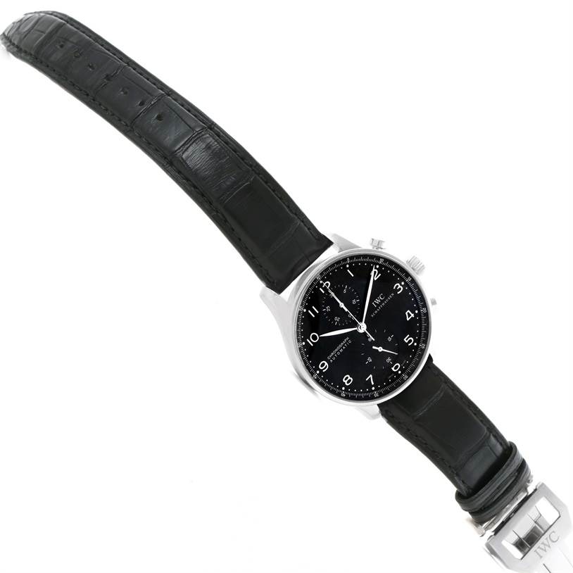 This image shows a top view of an IWC Portuguese IW371447 Men's Stainless Steel Black Dial IW371447 Men's Stainless Steel Black Dial model watch, displaying its black dial, leather strap, and clasp.