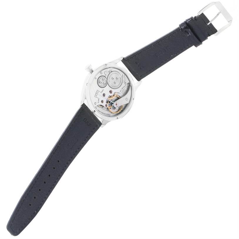 The image shows the backside of an IWC Portuguese IW544401 Men's Stainless Steel Silver Dial IW544401 Men's Stainless Steel Silver Dial model watch, highlighting its exposed movement and black leather strap.