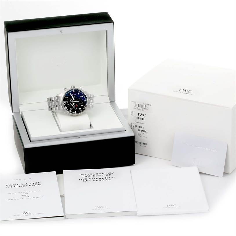 The IWC Pilot IW377704 Men's Stainless Steel Black Dial IW377704 Men's Stainless Steel Black Dial model watch is displayed at an angle in its box, alongside its warranty, instructions, and outer packaging.