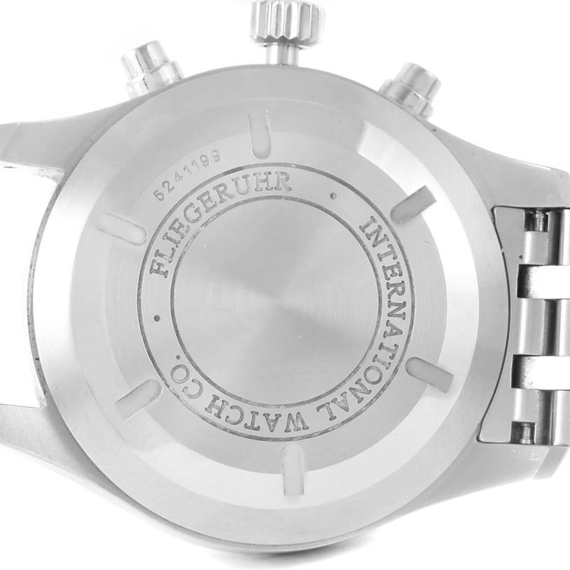 The image shows the back case of an IWC Pilot IW377704 Men's Stainless Steel Black Dial IW377704 Men's Stainless Steel Black Dial model watch, focusing on the engraving and the stainless steel band.