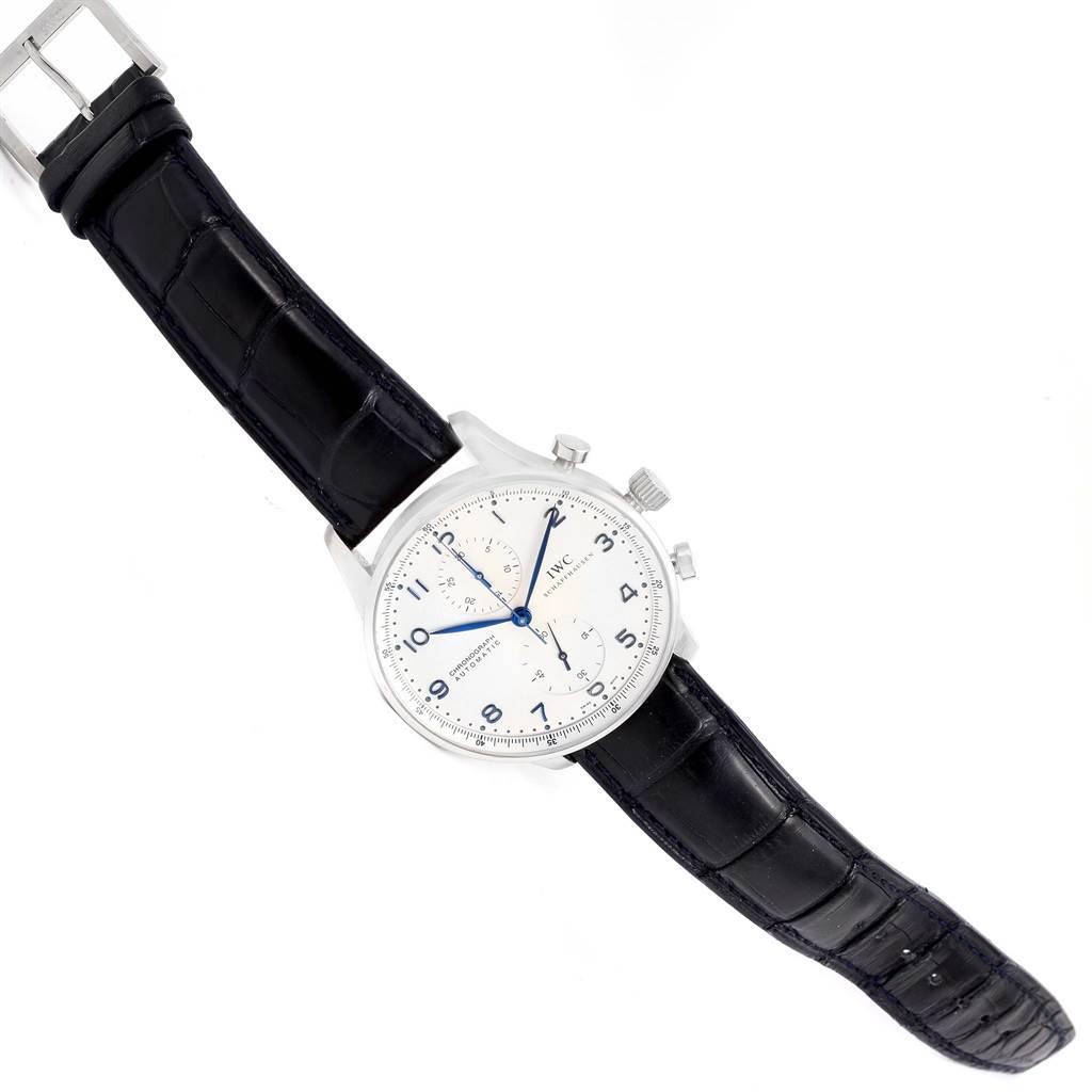 The IWC Portuguese IW371417 Men's Stainless Steel Silver Dial IW371417 Men's Stainless Steel Silver Dial model watch is displayed diagonally, showcasing its crocodile leather strap, silver case, white dial, and blue hands.