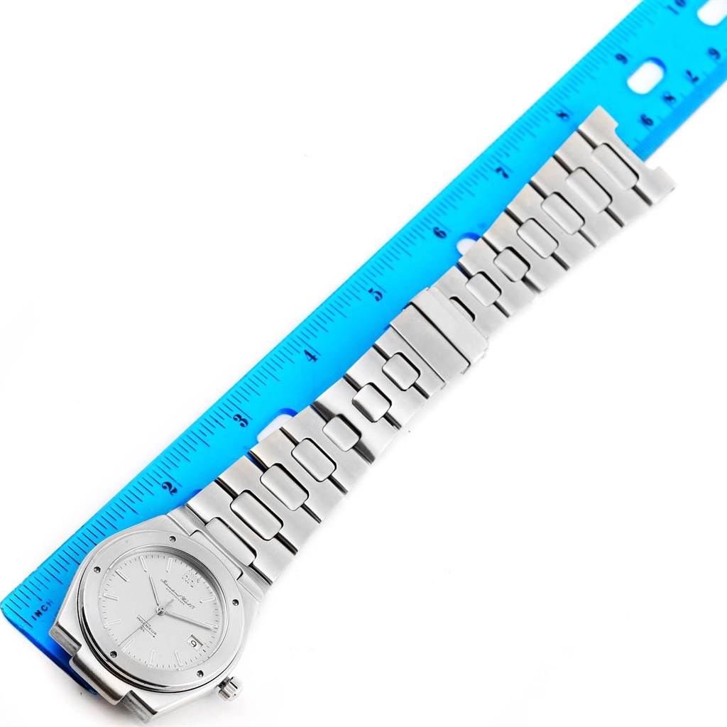 The IWC Ingenieur 1832 Stainless Steel Silver Dial 1832 Stainless Steel Silver Dial watch is shown from a top view, with a focus on its face and bracelet, placed alongside a blue ruler.