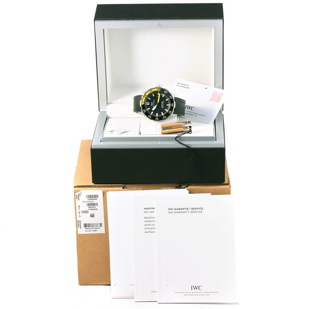 The image shows an IWC Aquatimer IW356808 Men's Stainless Steel Black Dial IW356808 Men's Stainless Steel Black Dial watch positioned inside an open display case, with manuals and accessories around it.