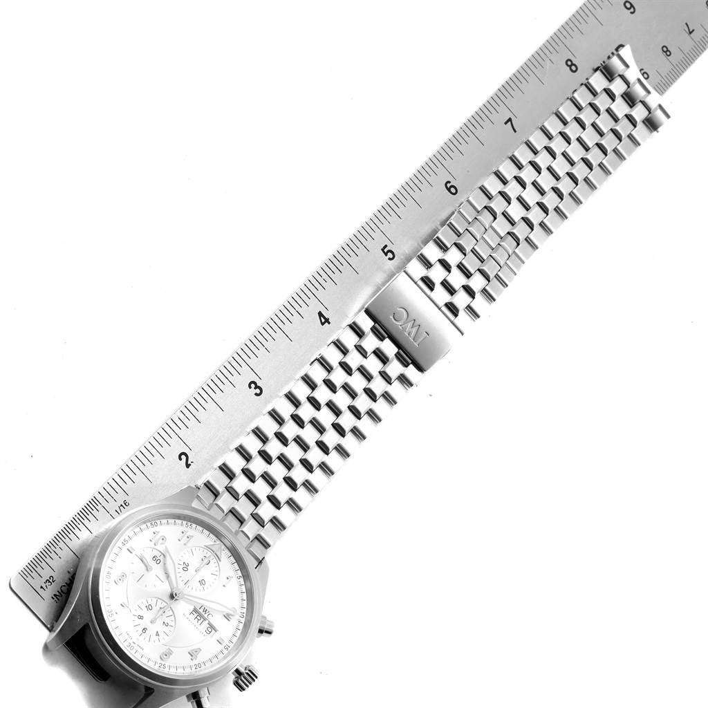 The image shows an IWC Pilot IW371705 Men's Stainless Steel Silver Dial IW371705 Men's Stainless Steel Silver Dial watch laid next to a ruler, highlighting the metal bracelet and clasp.