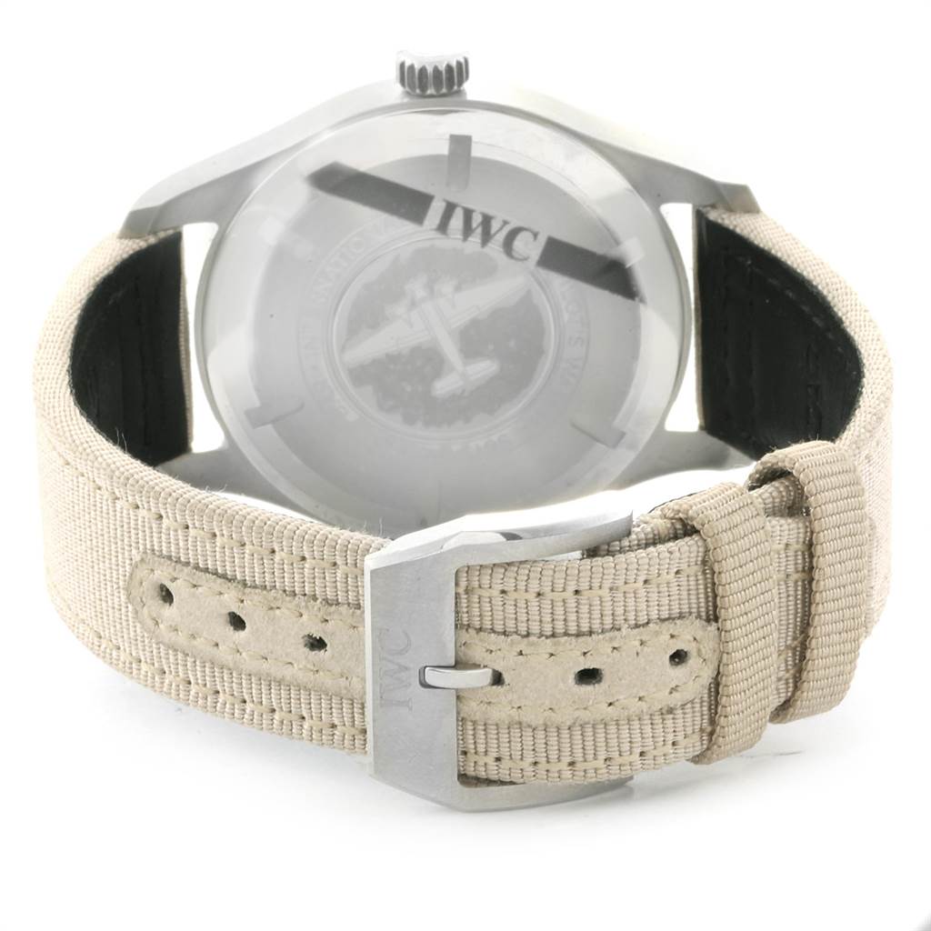 The image shows the back view of an IWC Pilot IW327017 Men's Stainless Steel Silver Dial IW327017 Men's Stainless Steel Silver Dial model watch, highlighting the case back, crown, and beige fabric strap with a buckle.