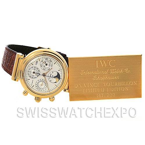 The image shows an IWC Da Vinci IW375203 OR 3752-03 OR 3752-003 Men's Yellow Gold Silver Dial IW375203 OR 3752-03 OR 3752-003 Men's Yellow Gold Silver Dial watch at a slight angle, displaying the face and leather strap, alongside a gold plaque.