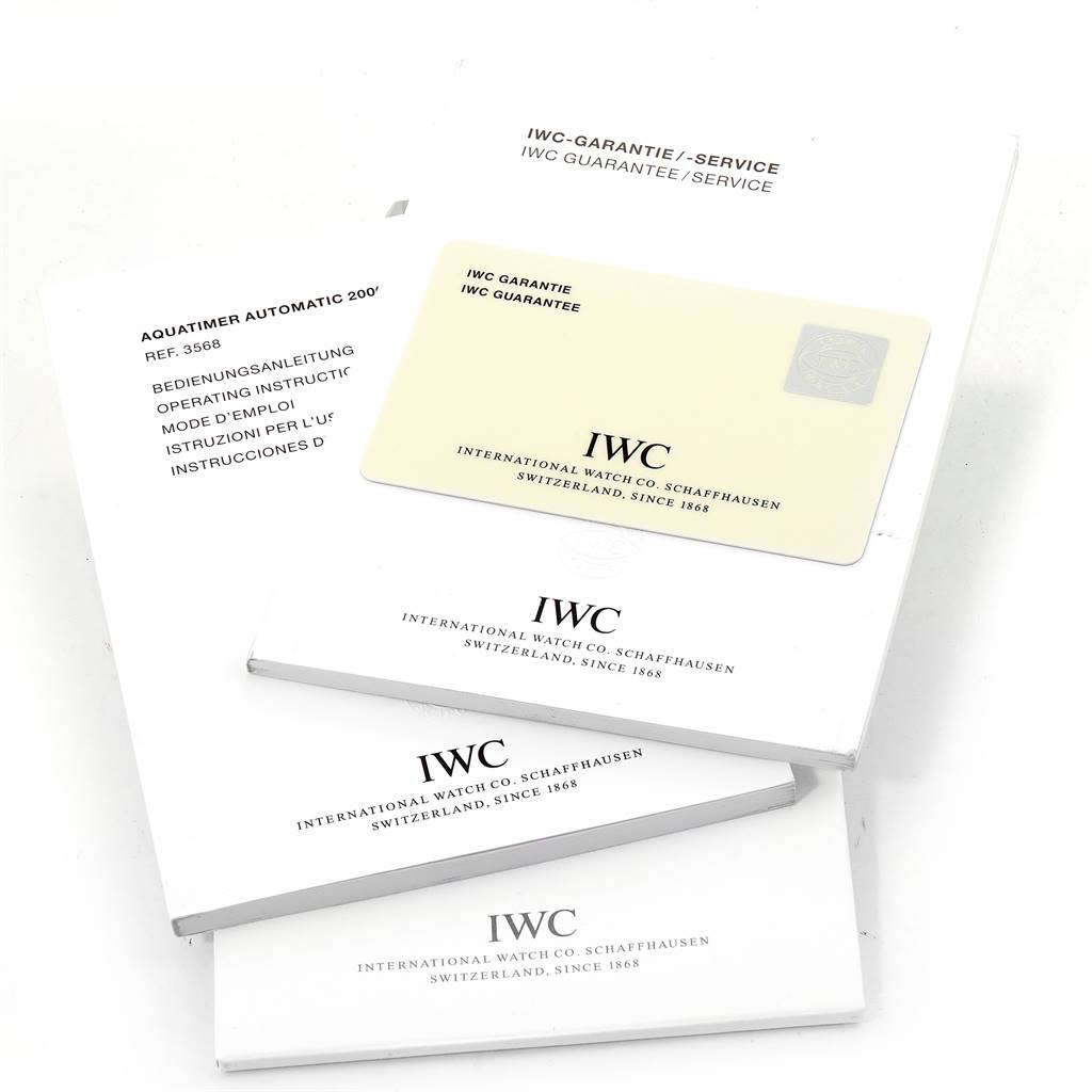 The image shows stacked IWC Aquatimer IW356801 Men
s Stainless Steel Black Dial IW356801 Men
s Stainless Steel Black Dial model operating instructions, a guarantee card, and warranty/service booklets.