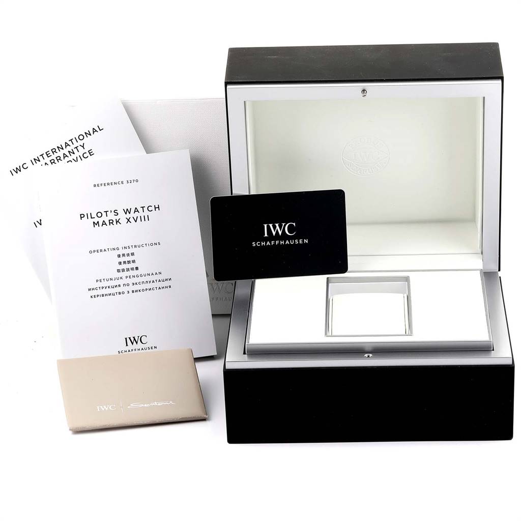 The image shows the packaging and documentation for the IWC Pilot IW327001 Men's Stainless Steel Black Dial IW327001 Men's Stainless Steel Black Dial's Watch Mark XVIII, including the box, manuals, and warranty card.