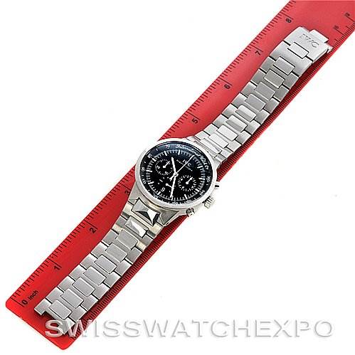 This image shows an overhead view of an IWC Vintage Men's Stainless Steel Black Dial Men's Stainless Steel Black Dial model watch with a silver metal bracelet on a red ruler.