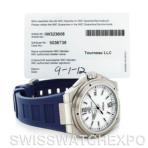 The image shows an IWC Ingenieur IW323608 Men's Stainless Steel White Dial IW323608 Men's Stainless Steel White Dial watch with a blue strap, placed at an angle revealing the watch's face and a warranty card.