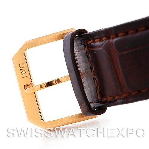 The image shows the buckle of an IWC Portuguese IW3714-15 Men's Rose Gold Black Dial IW3714-15 Men's Rose Gold Black Dial model watch strap at a close angle, highlighting its gold-tone clasp and brown leather material.
