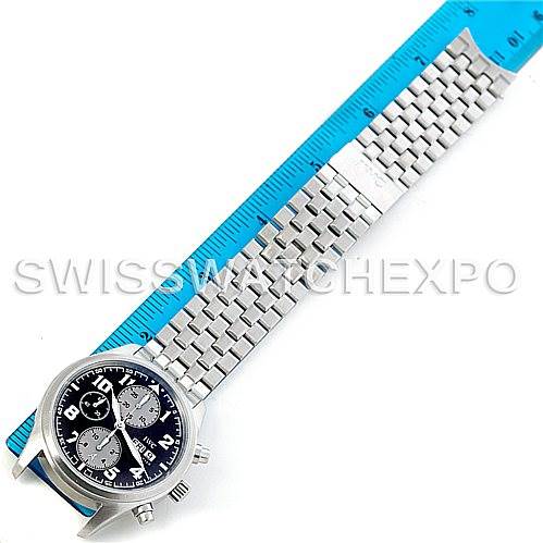 The IWC Pilot Men
s Stainless Steel Black Dial Men
s Stainless Steel Black Dial model watch is shown with a silver metal bracelet, taken from an overhead angle next to a blue ruler for size reference.