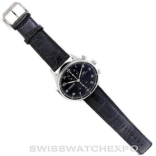 The image shows the IWC Portuguese IW371447 Men
s Stainless Steel Black Dial IW371447 Men
s Stainless Steel Black Dial watch fully extended, with a silver case and a black leather strap, viewed from above.