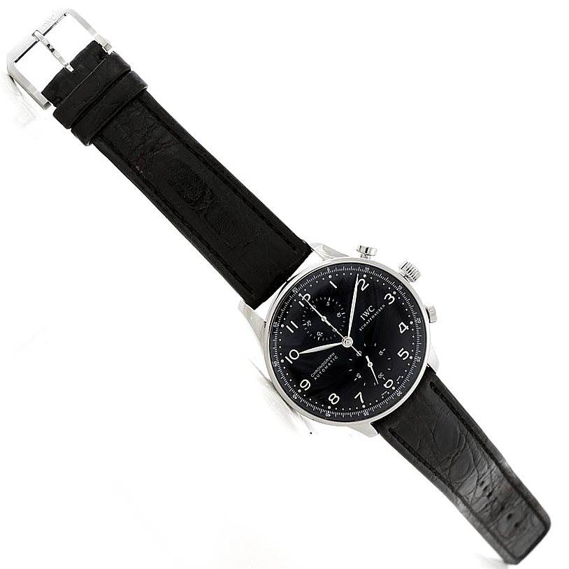 The image shows a top-down view of the IWC Portuguese IW371438 Men
s Stainless Steel Black Dial IW371438 Men
s Stainless Steel Black Dial model watch, featuring a black leather strap and a black dial.