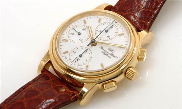 This image shows a Vintage IWC watch from a slightly oblique angle, highlighting its gold case, dial, and leather strap.