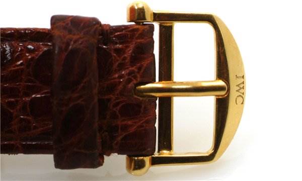 This image shows the gold buckle and leather strap of a Vintage IWC watch, viewed from the front and side-angle.