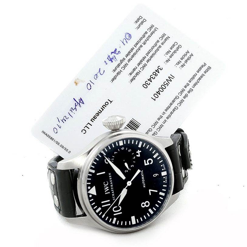 The image shows an IWC Pilot IW500401 Men's Stainless Steel Black Dial IW500401 Men's Stainless Steel Black Dial model watch from a front-facing angle with a visible crown and part of the strap, along with a warranty card.