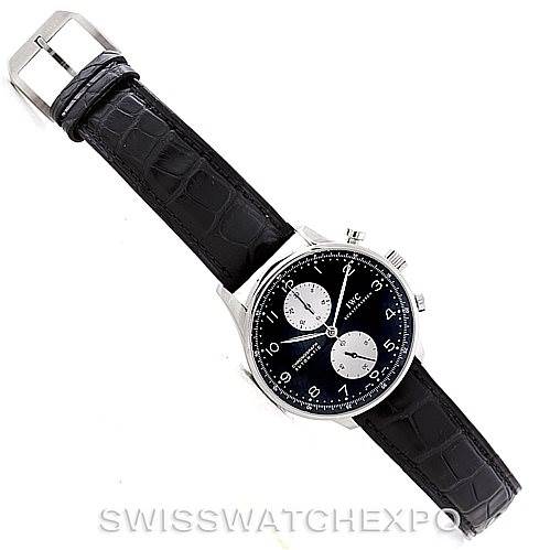 The image shows a top view of the IWC Portuguese IW371404 Men
s Stainless Steel Black Dial IW371404 Men
s Stainless Steel Black Dial watch, displaying its black leather strap and black dial with silver subdials.