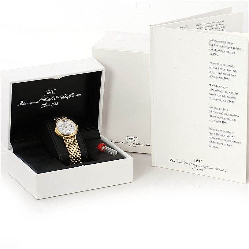 The image shows an IWC Portofino 3541 Men's Yellow Gold White Dial 3541 Men's Yellow Gold White Dial watch in its box, accompanied by manuals and additional accessories.