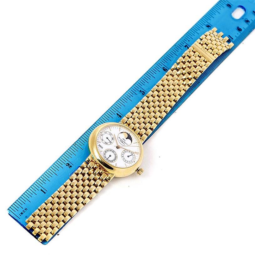 The IWC Portofino 3541 Men's Yellow Gold White Dial 3541 Men's Yellow Gold White Dial watch is shown lying flat next to a blue ruler, highlighting its golden band and dial.