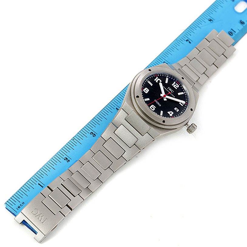 The image shows an overhead shot of the IWC Ingenieur IW322703 Men's Titanium Black Dial IW322703 Men's Titanium Black Dial watch, displaying its face, bezel, bracelet, and clasp.