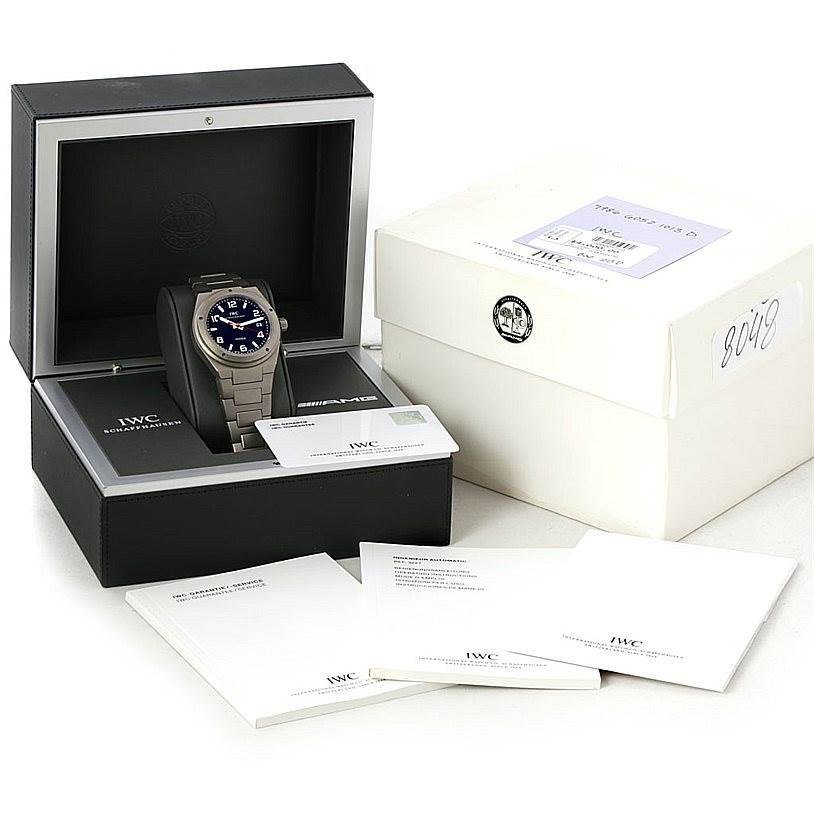 The IWC Ingenieur IW322703 Men's Titanium Black Dial IW322703 Men's Titanium Black Dial watch is shown in its open box along with a white outer box, warranty card, and booklets.