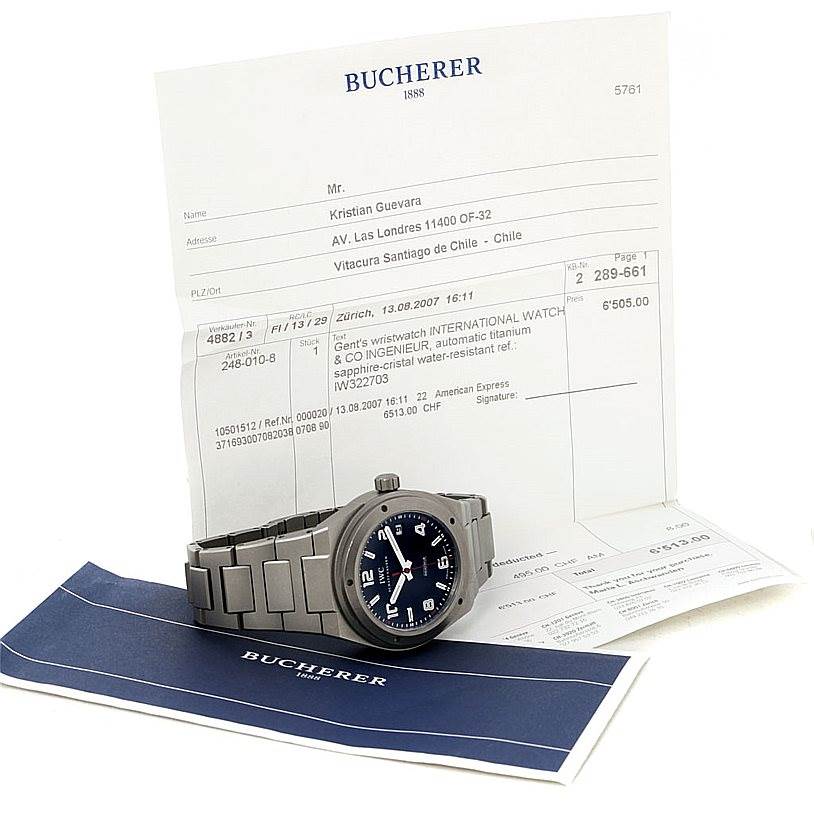 The IWC Ingenieur IW322703 Men's Titanium Black Dial IW322703 Men's Titanium Black Dial watch is displayed at an angle showing the face and bracelet, alongside sales documents.