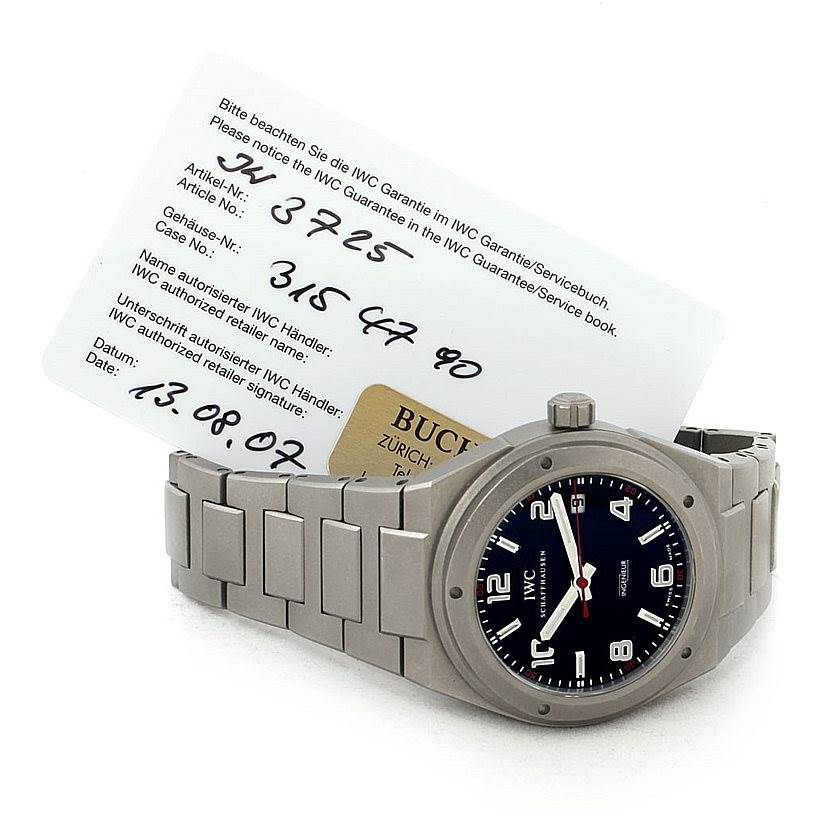 The image shows an IWC Ingenieur IW322703 Men's Titanium Black Dial IW322703 Men's Titanium Black Dial watch at an angle displaying the face, bezel, and part of the bracelet, accompanied by a guarantee card.