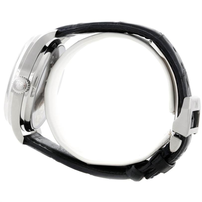 The IWC Portuguese IW500107 Men's Stainless Steel Silver Dial IW500107 Men's Stainless Steel Silver Dial watch is shown from a side angle, highlighting its case, crown, black strap, and clasp.