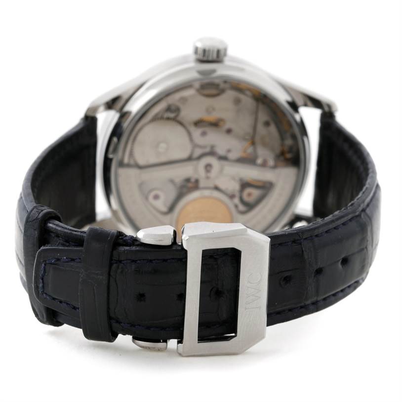 The image shows the back view of an IWC Portuguese IW500107 Men's Stainless Steel Silver Dial IW500107 Men's Stainless Steel Silver Dial model watch, focusing on its movement and black leather strap.