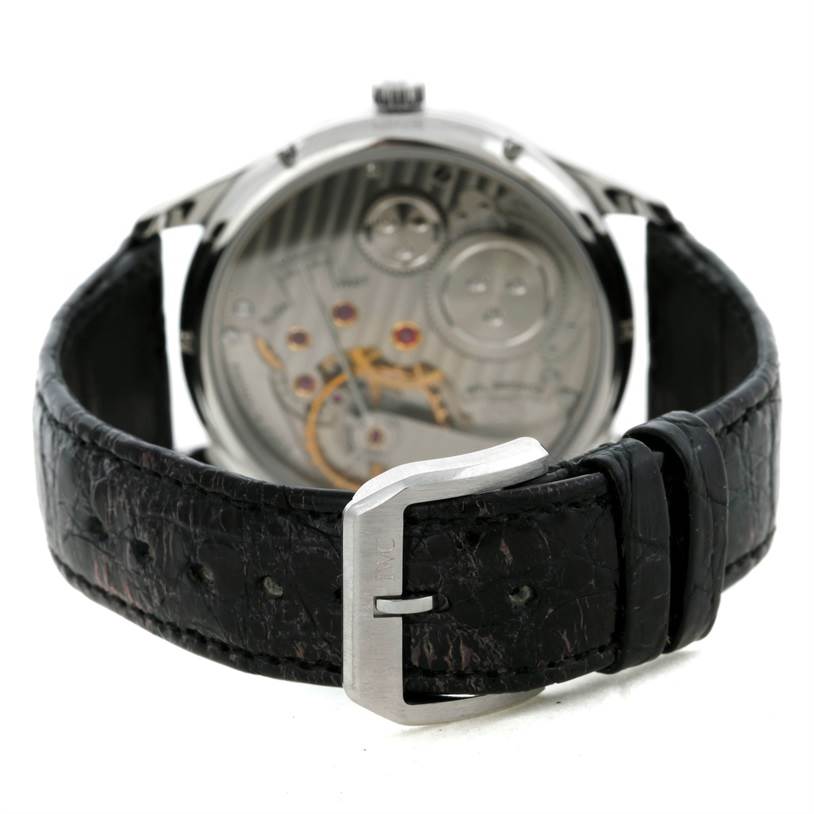 The image shows the back view of an IWC Portuguese IW545405 Men's Stainless Steel Silver Dial IW545405 Men's Stainless Steel Silver Dial model watch, highlighting its movement mechanism and black leather strap.