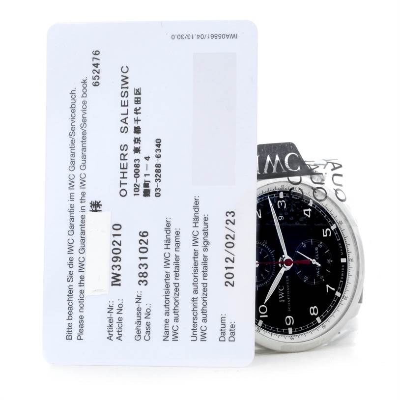 The image shows the face of the IWC Portuguese IW390210 Men's Stainless Steel Black Dial IW390210 Men's Stainless Steel Black Dial model watch, partially obscured by a warranty card.