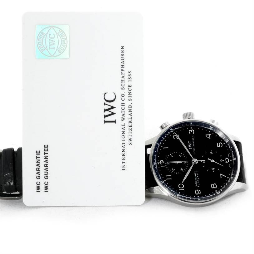 The image shows a black IWC Portuguese IW371438 Men's Stainless Steel Black Dial IW371438 Men's Stainless Steel Black Dial model watch face and warranty card side by side.