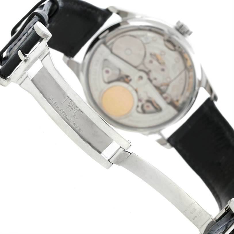 The image shows the backside of the IWC Portuguese IW500107 Men's Stainless Steel Silver Dial IW500107 Men's Stainless Steel Silver Dial model watch, focusing on the movement and metal clasp of the strap.