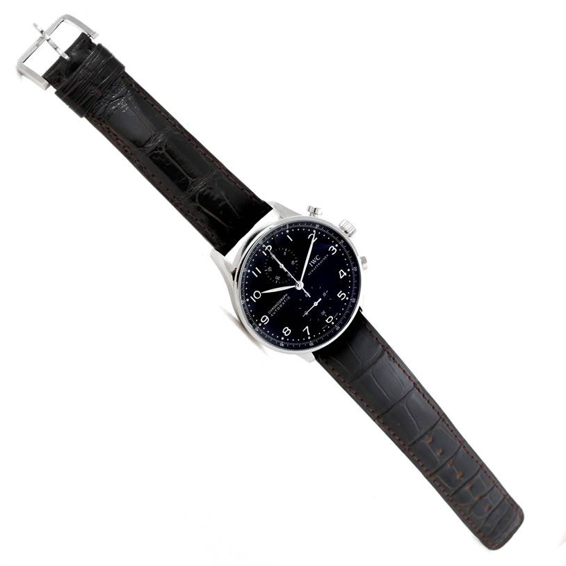 The IWC Portuguese IW371438 Men's Stainless Steel Black Dial IW371438 Men's Stainless Steel Black Dial model watch is shown at a slight angle, displaying the face, leather strap, buckle, and side buttons.