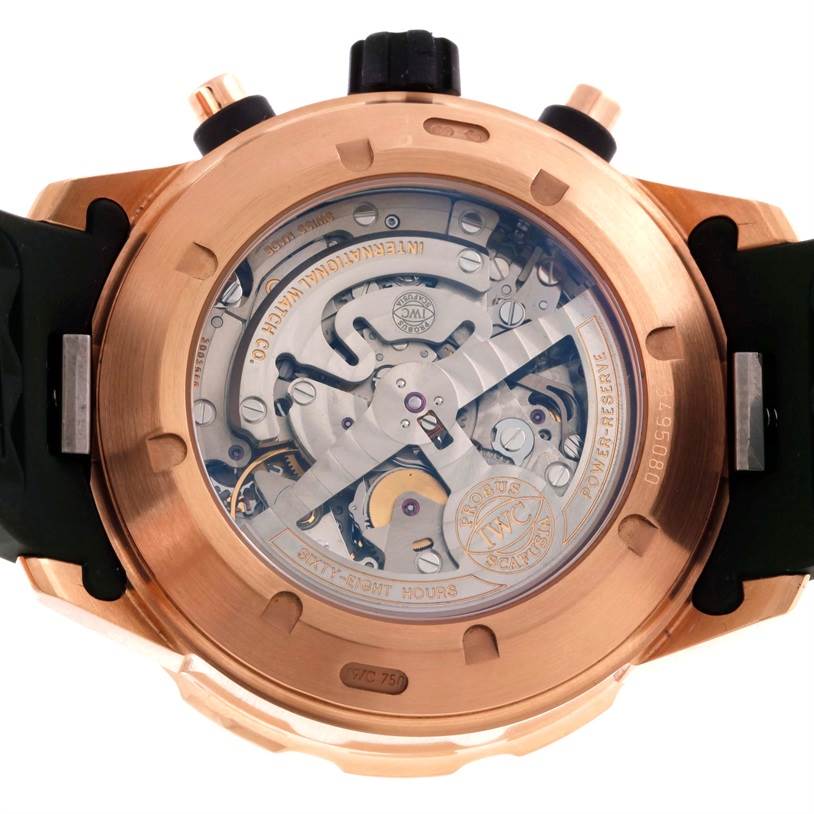 The image shows the back view of an IWC Aquatimer IW376903 Men's Rose Gold Black Dial IW376903 Men's Rose Gold Black Dial watch, displaying the intricate movements and mechanisms through a transparent case back.