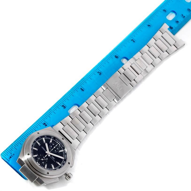 The image shows an IWC Ingenieur IW372501 Men's Stainless Steel Black Dial IW372501 Men's Stainless Steel Black Dial watch laid flat with its bracelet and a blue ruler for scale.