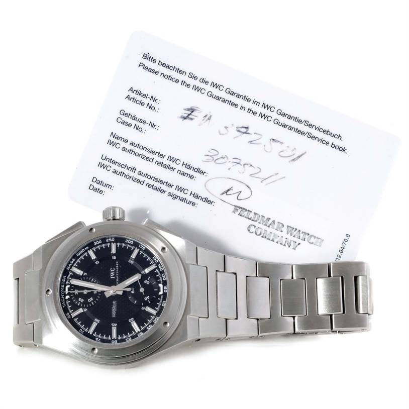 The IWC Ingenieur IW372501 Men's Stainless Steel Black Dial IW372501 Men's Stainless Steel Black Dial watch is shown from a top-down angle with its steel bracelet and warranty card visible.