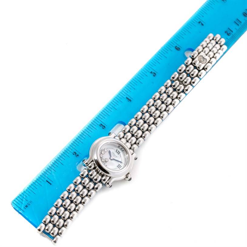 This image shows a top view of the Chopard 27/8250-23 Women
s Stainless Steel White Dial 27/8250-23 Women
s Stainless Steel White Dial Happy Sport White Dial 5 Floating Diamonds Watch 27/8250-23 alongside a blue ruler.