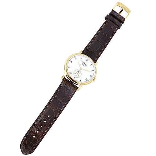 The image shows a top-down view of the Chopard 16-1223 Yellow Gold White Dial 16-1223 Yellow Gold White Dial Les Classique Luc Homme 18k Yellow Gold 16/1223 watch, highlighting its dial and leather strap.