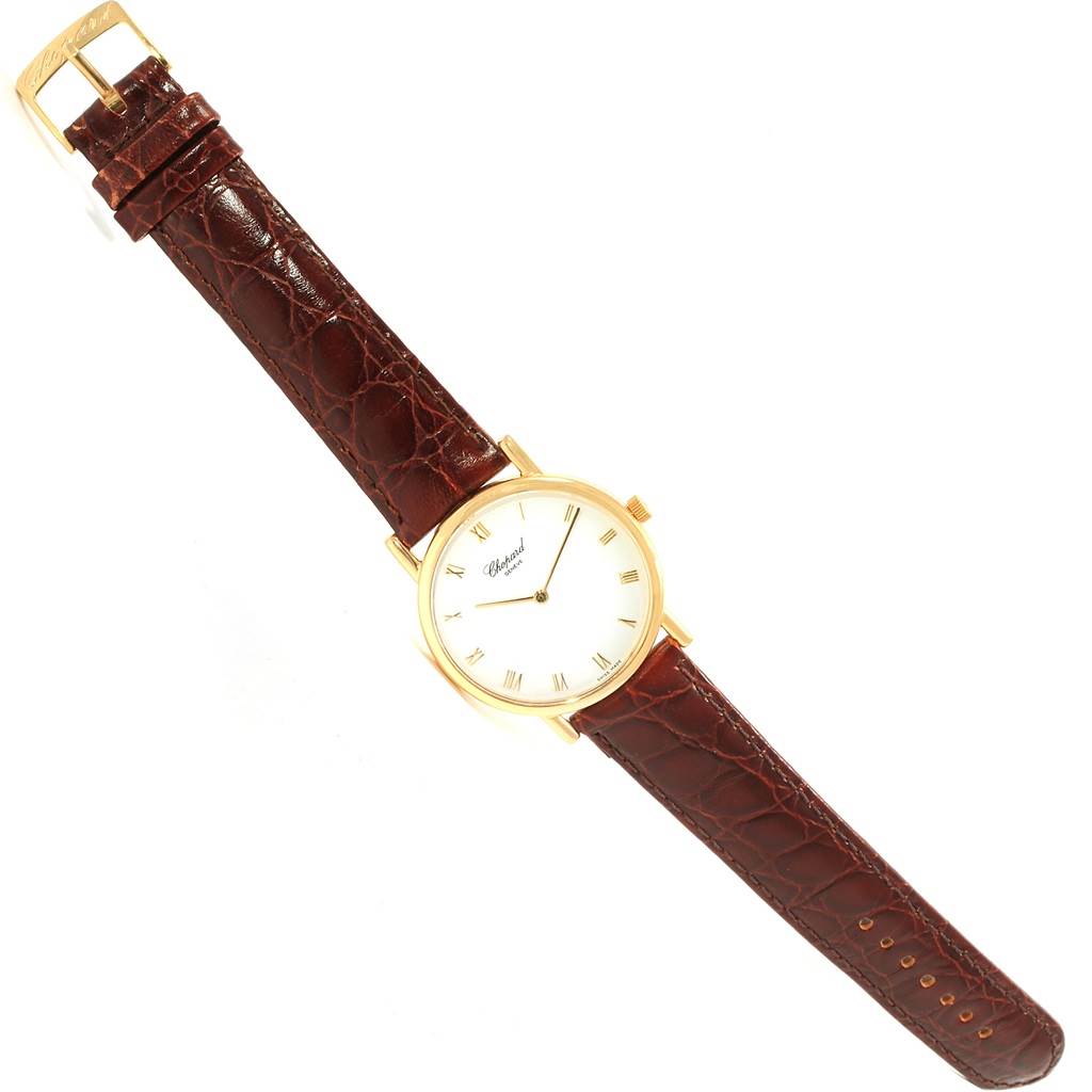 The Chopard Classique 16/3154 Men's Yellow Gold White Dial 16/3154 Men's Yellow Gold White Dial watch is shown from a top-down angle, highlighting its gold case and brown leather strap.