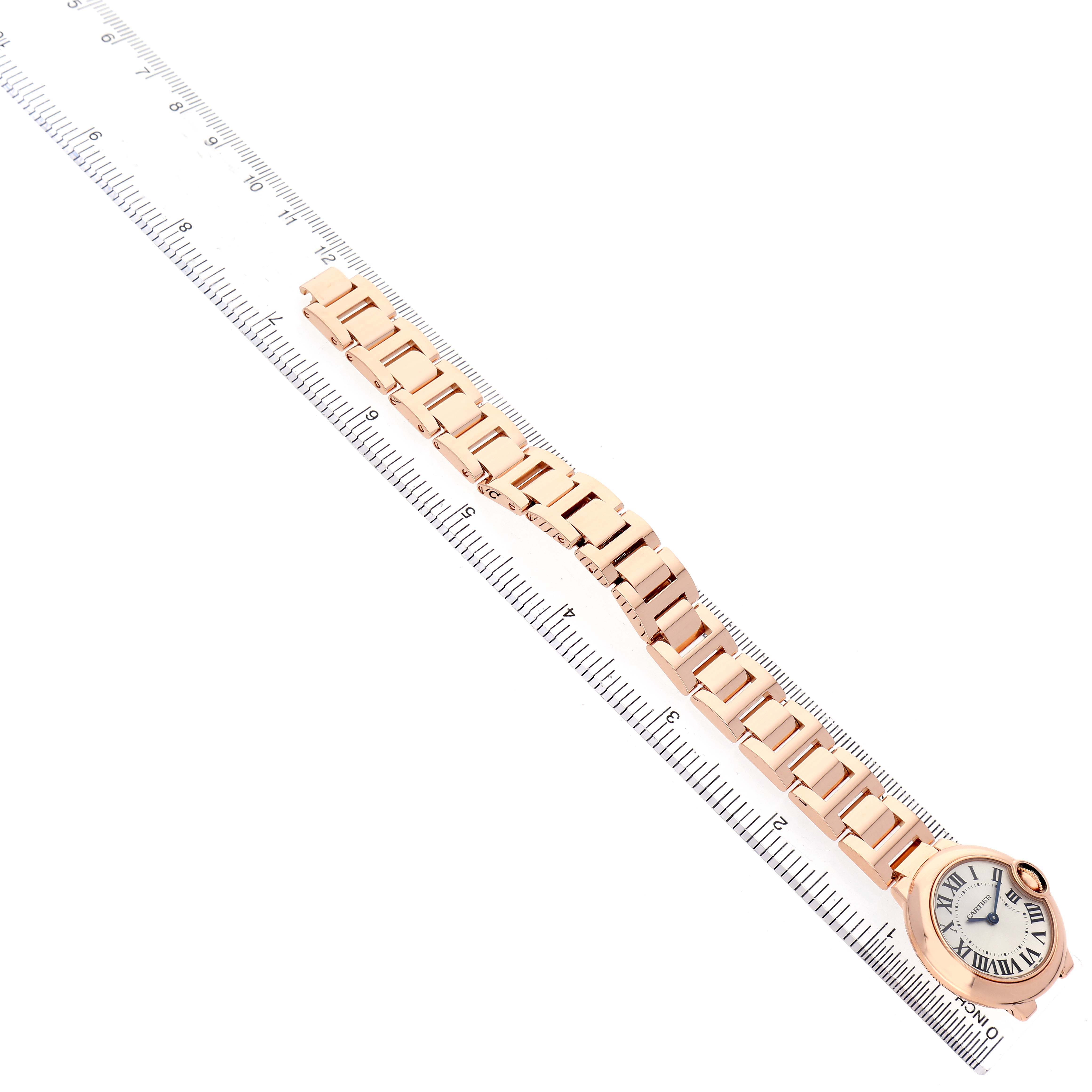 The image shows a Cartier Ballon Bleu W69002Z2 Women's Rose Gold Silver Dial watch from an angled top view, highlighting its bracelet and face next to a ruler.