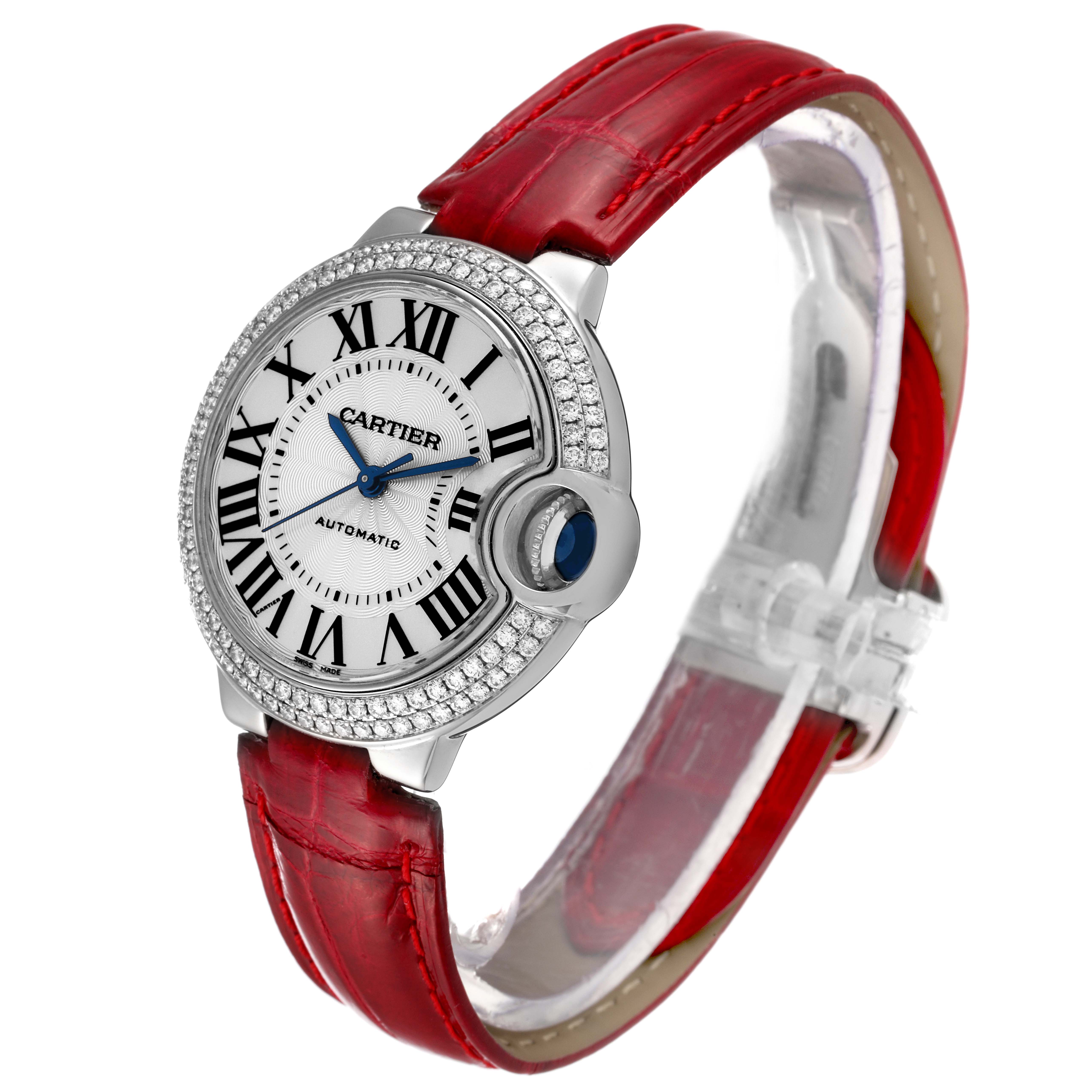 The image shows a side angle of the Cartier Ballon Bleu WE902067 Women
s White Gold Silver Dial WE902067 Women
s White Gold Silver Dial watch with a red leather strap and diamond-encrusted bezel.