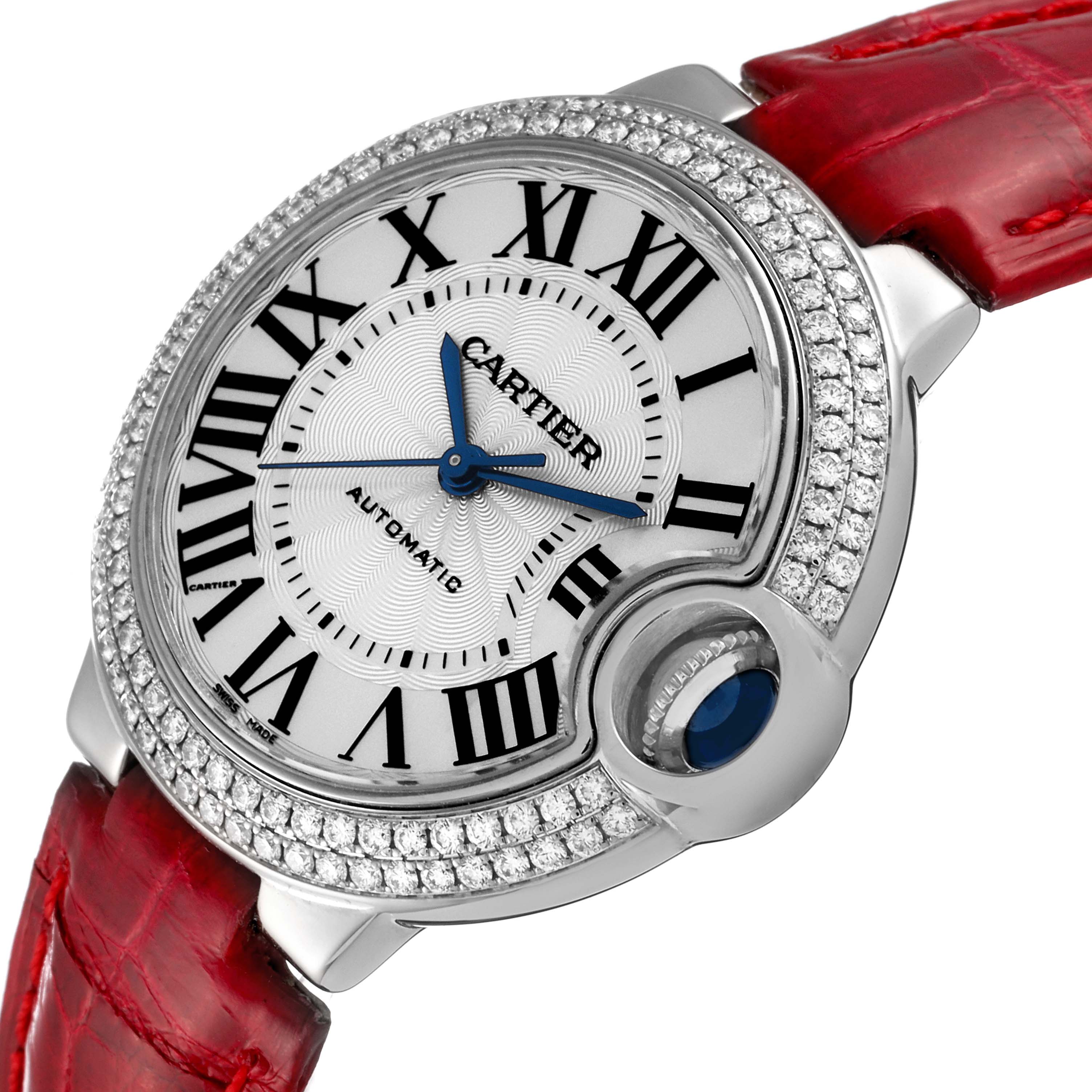 The image shows a Cartier Ballon Bleu WE902067 Women
s White Gold Silver Dial WE902067 Women
s White Gold Silver Dial watch from a front angle, featuring a diamond-covered bezel and a red leather strap.