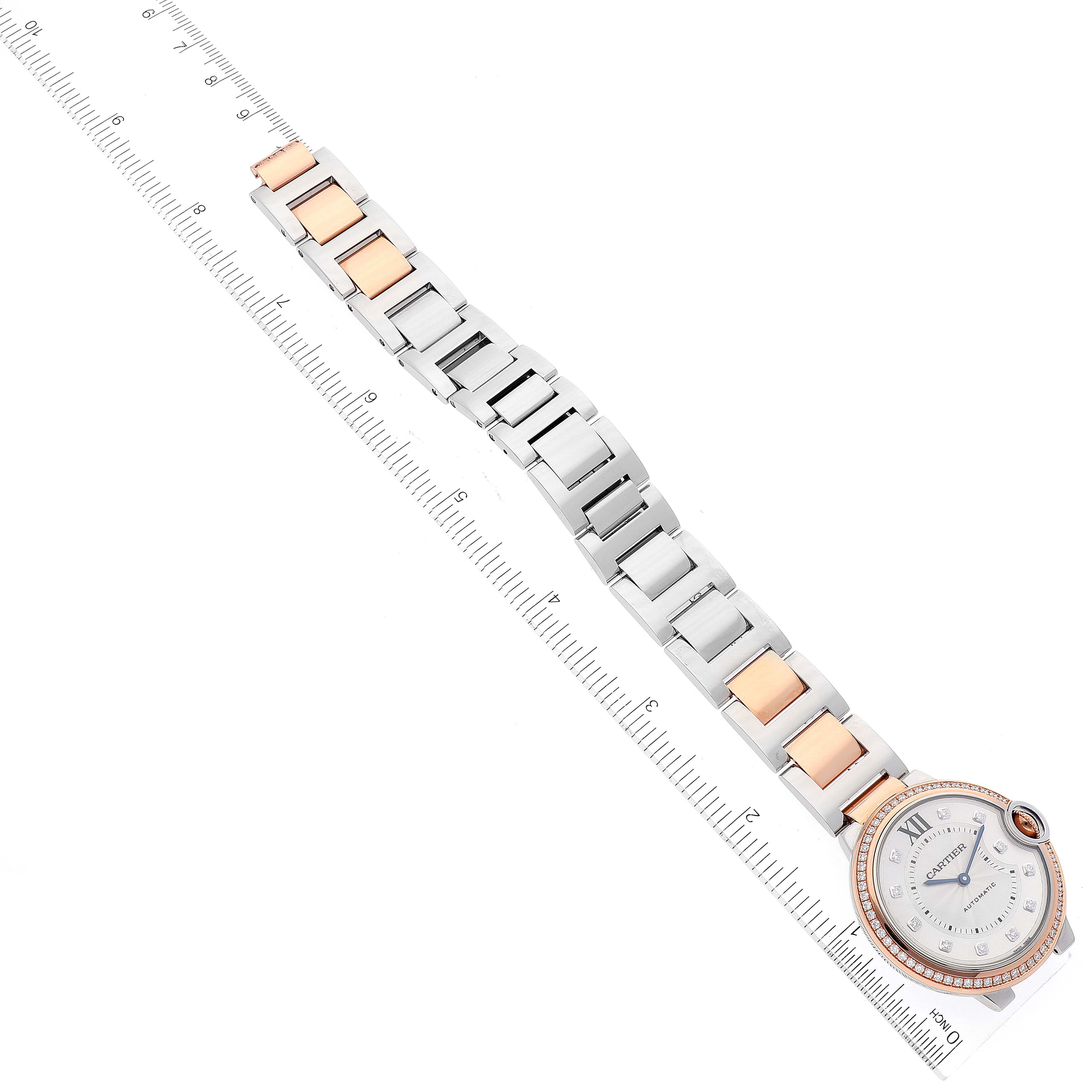 The Cartier Ballon Bleu W3BB0004 Women's Steel and Gold (two tone) Silver Dial W3BB0004 Women's Steel and Gold (two tone) Silver Dial watch is shown from a top view, displaying its bracelet and face beside a ruler for scale.