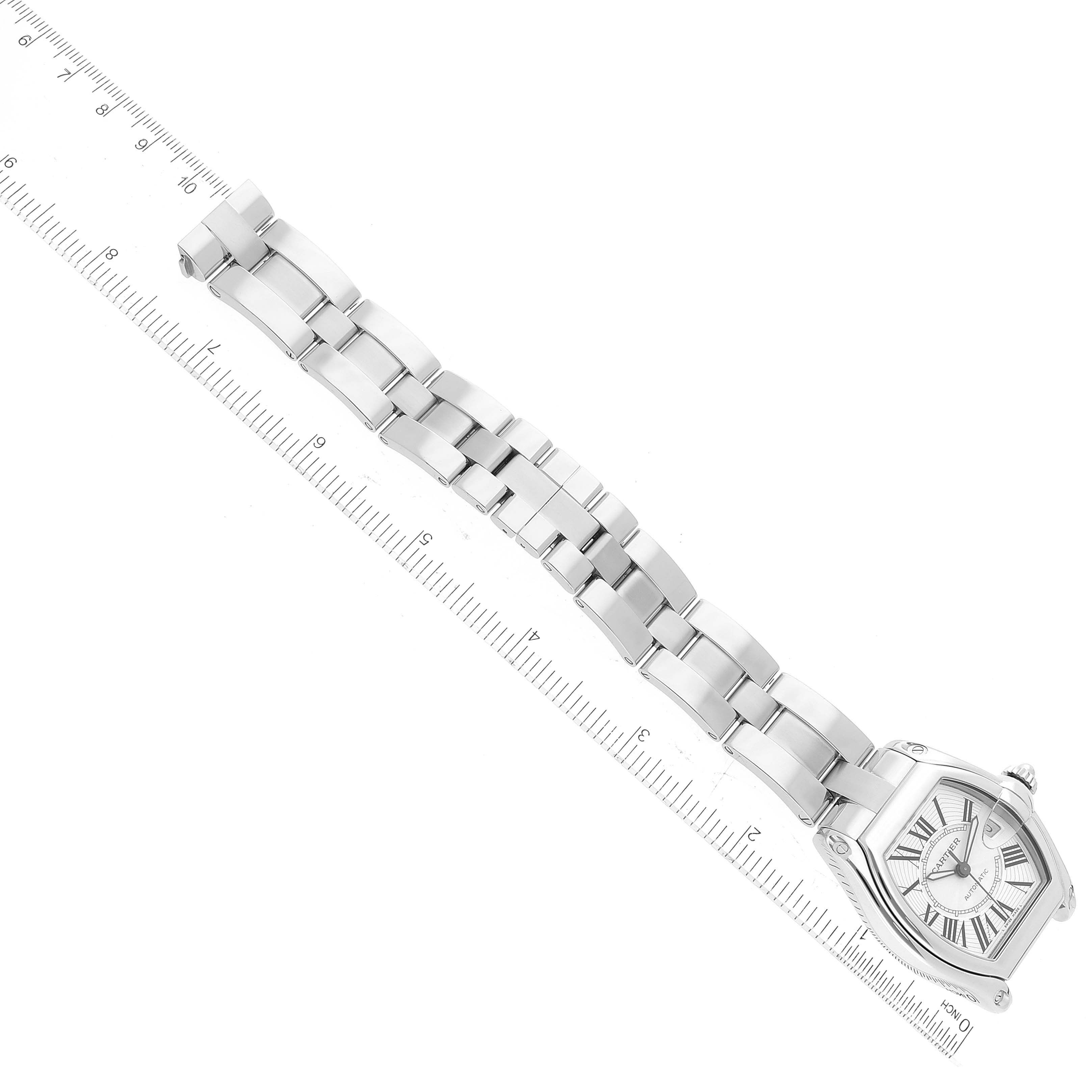 The image shows the Roadster model by Cartier from a top-down angle, highlighting its watch face and metal bracelet beside a ruler.