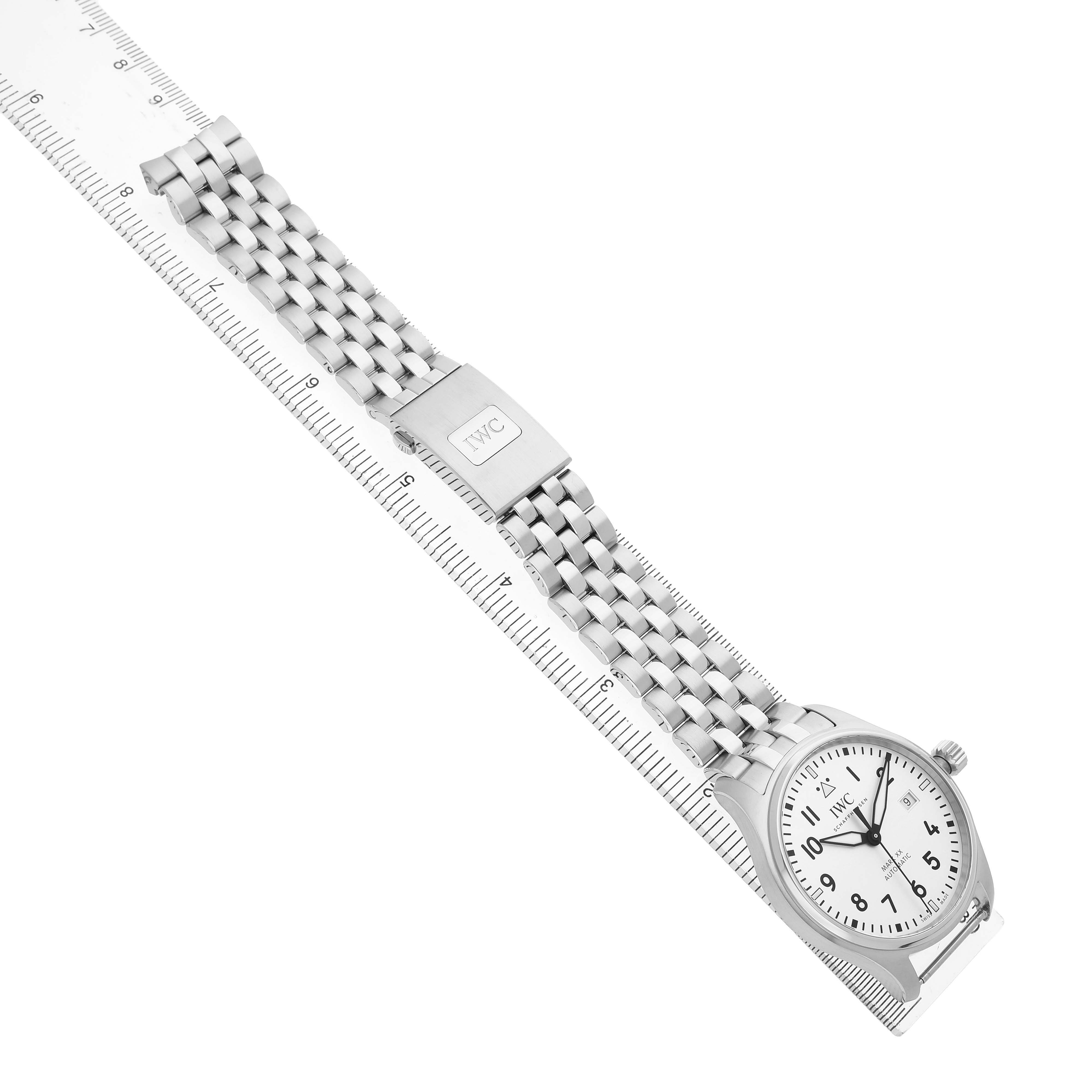 The IWC Pilot IW328207 Men's Stainless Steel Silver Dial model watch is shown from a top angle, displaying its dial, bracelet, and clasp fully extended next to a ruler.