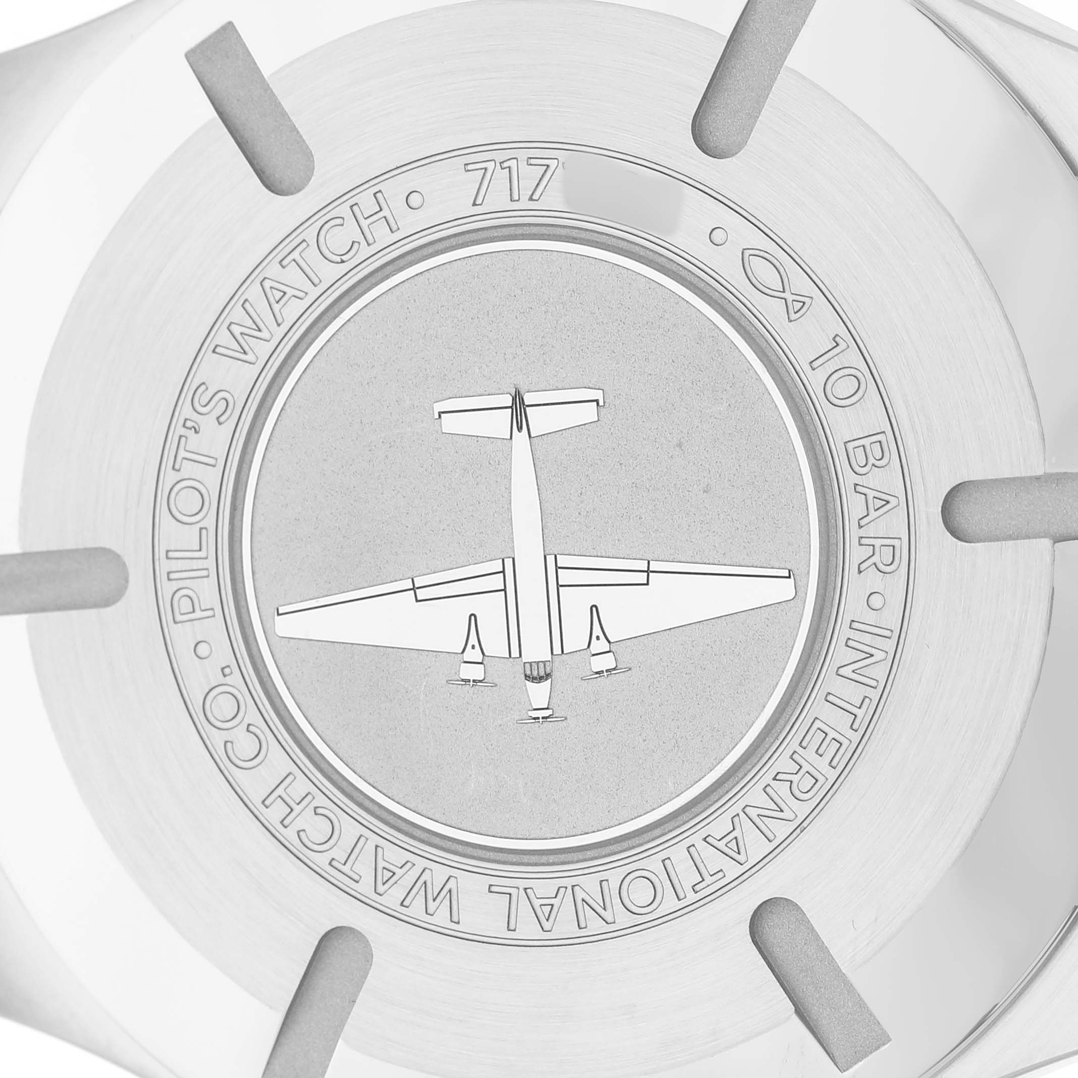 The image shows the back case of an IWC Pilot IW328207 Men's Stainless Steel Silver Dial model watch featuring an engraved airplane design and specifications.