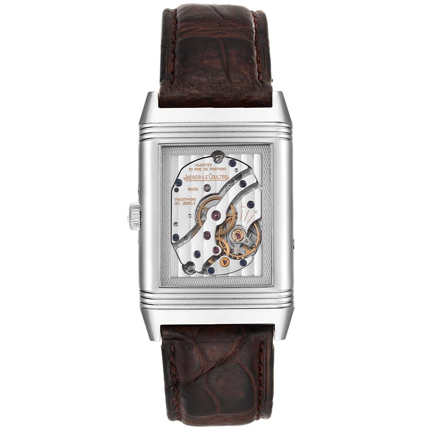 The image shows the back of a Jaeger-LeCoultre Reverso watch, highlighting its exposed mechanical movement and leather strap.